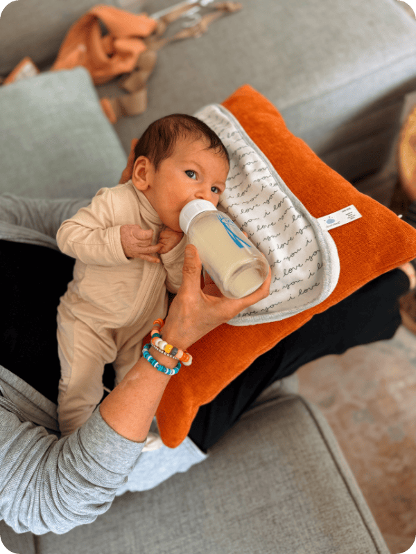Nana gives newborn baby a bottle of milk.