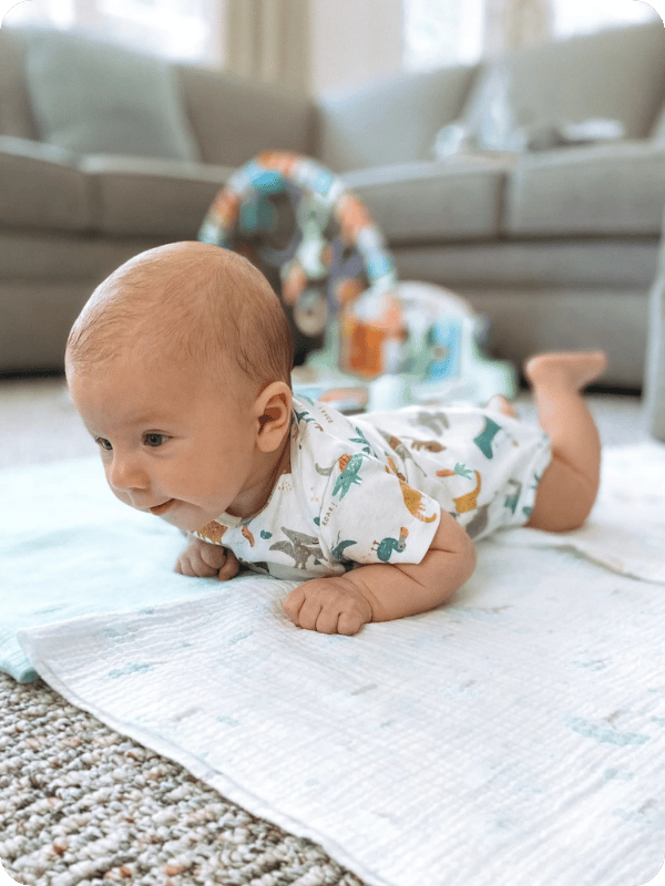 A young infant practices tummy time on the floor.