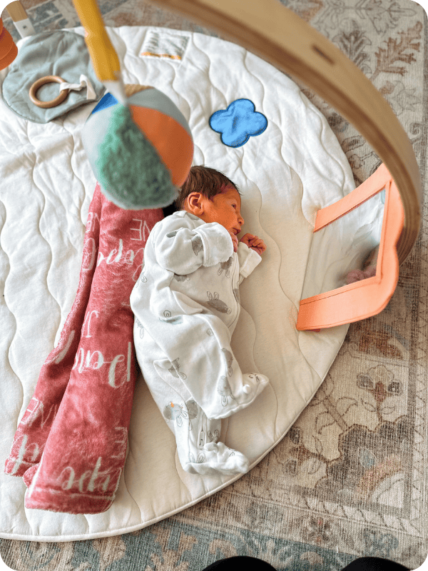 Newborn baby practicing sidelying on a tummy time mat
