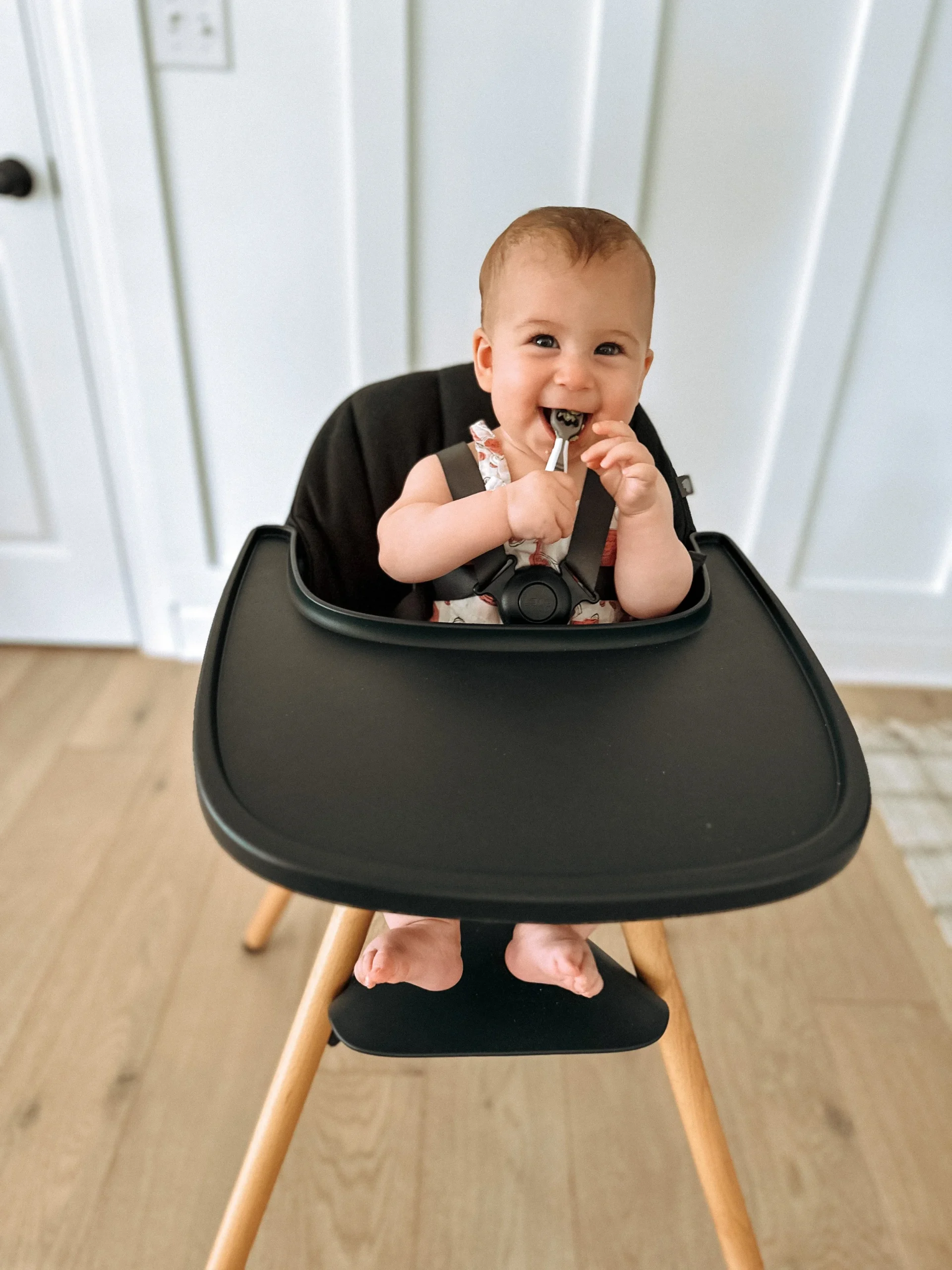 This baby is sitting upright. This is a much more optimal position for baby, as they can reach all of the food and utensils on the tray and it’s much safer for swallowing!
