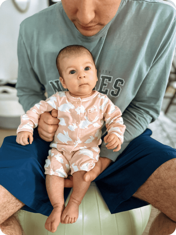 Dad holds infant against his chest so that the baby can look out at the world.