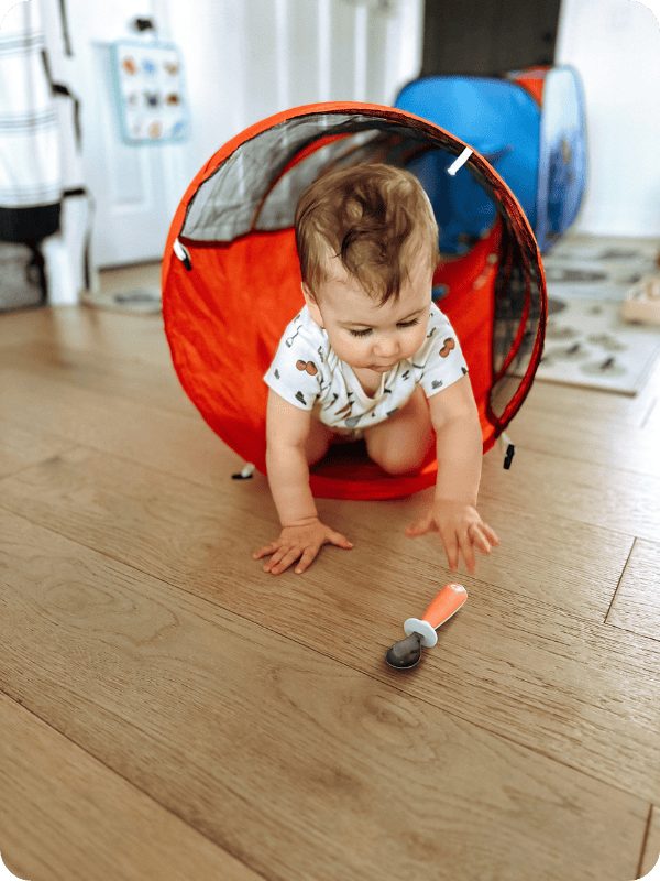 9 month old plays with a pop-up tunnel toy.