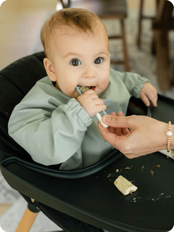 Baby eats from a preloaded spoon.