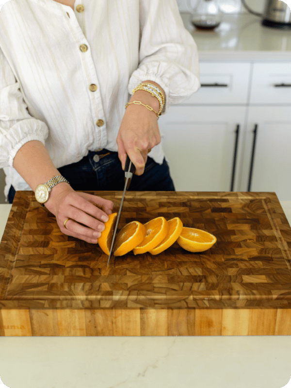 Mom cuts orange slices.