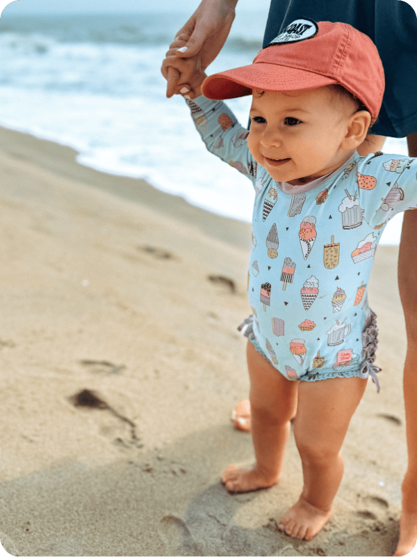 baby by the ocean wearing rufflebutts baby girl swimsuit