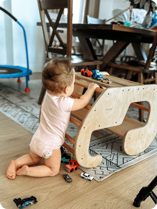 Infant kneels to play with a toy