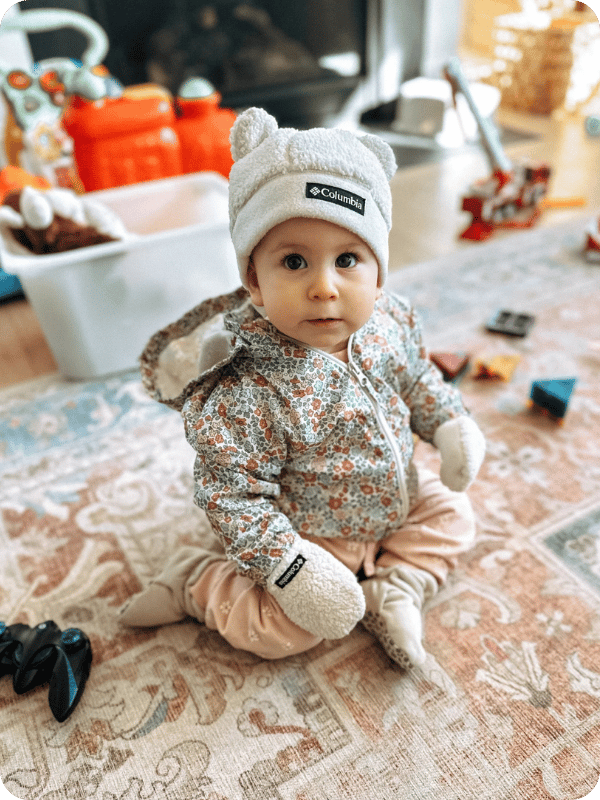 Infant in winter clothes side sitting