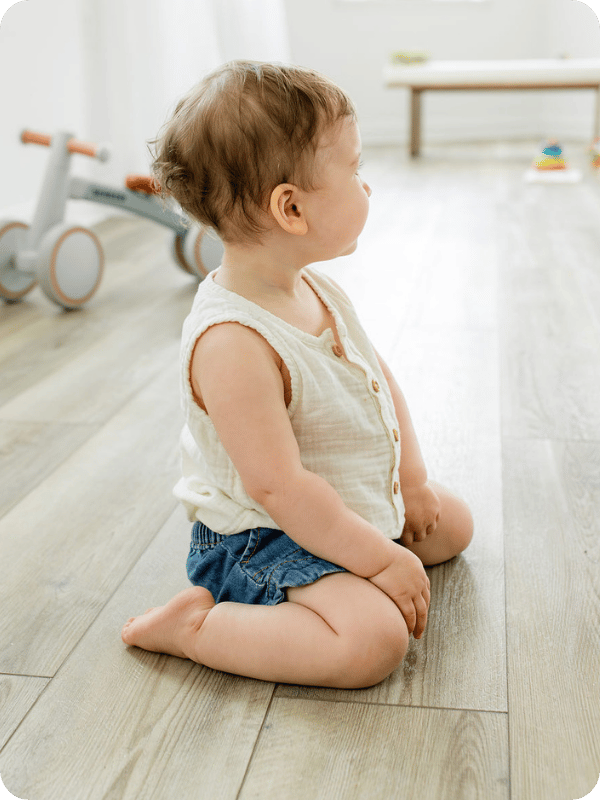 Infant sits upright in the W sit position