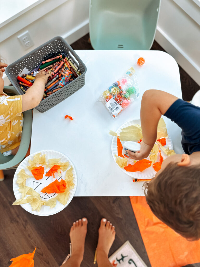toddlers working on fall crafts at a table