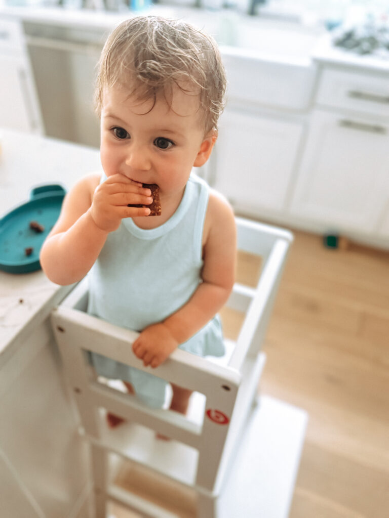 toddler girl eating a fruit bar in the SDADI learning tower