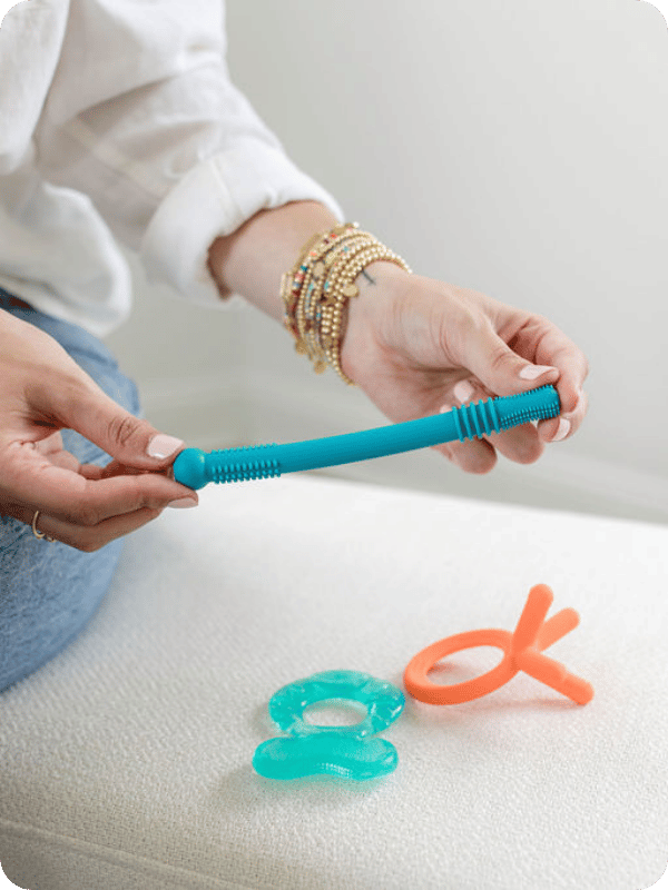 Jordyn holds a hollow tube teether up to the camera