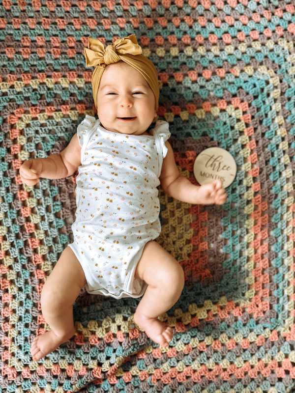 Three month old baby laying on floor