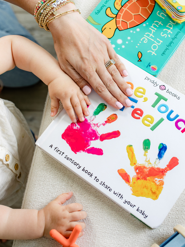 mother and baby touching a book together