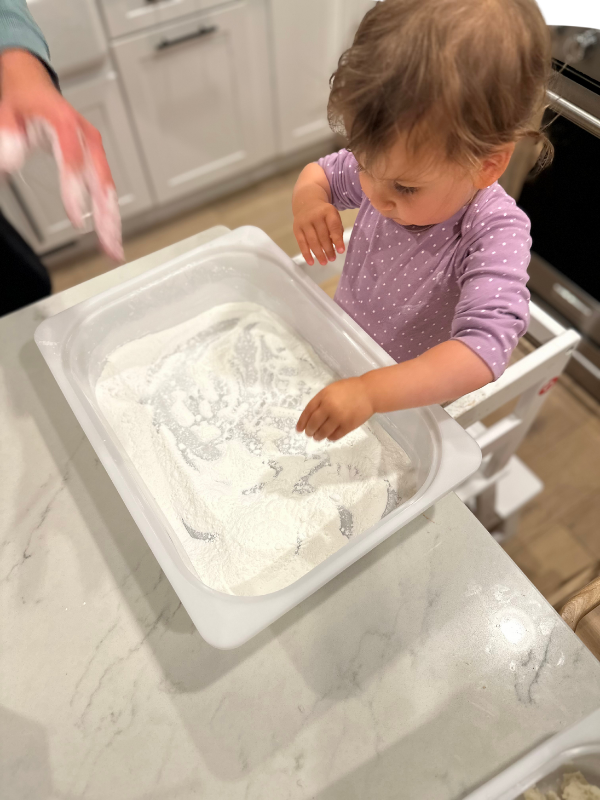 toddler plays with edible sensory bin