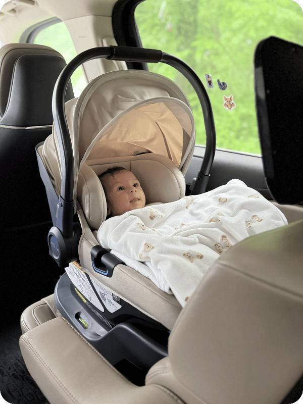 infant sitting in Uppababy Aria carseat, buckled in during car ride