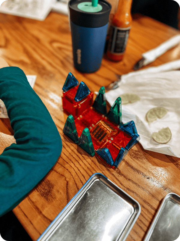 MAGNA-TILES travel set being used to build at a restaurant table