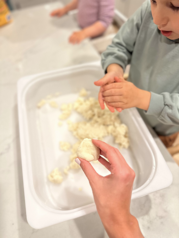 toddler plays with edible sensory bin