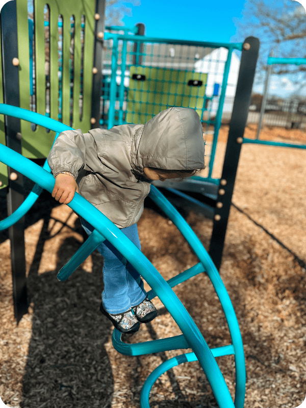 toddler climbing on playground with Leisfit toddler boots
