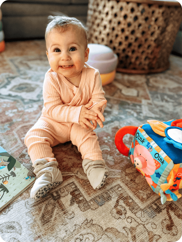 baby sitting up playing with Melissa and Doug Farmyard Cube