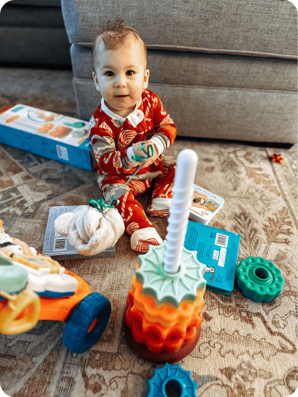 baby sitting up playing with stacking spinner toy