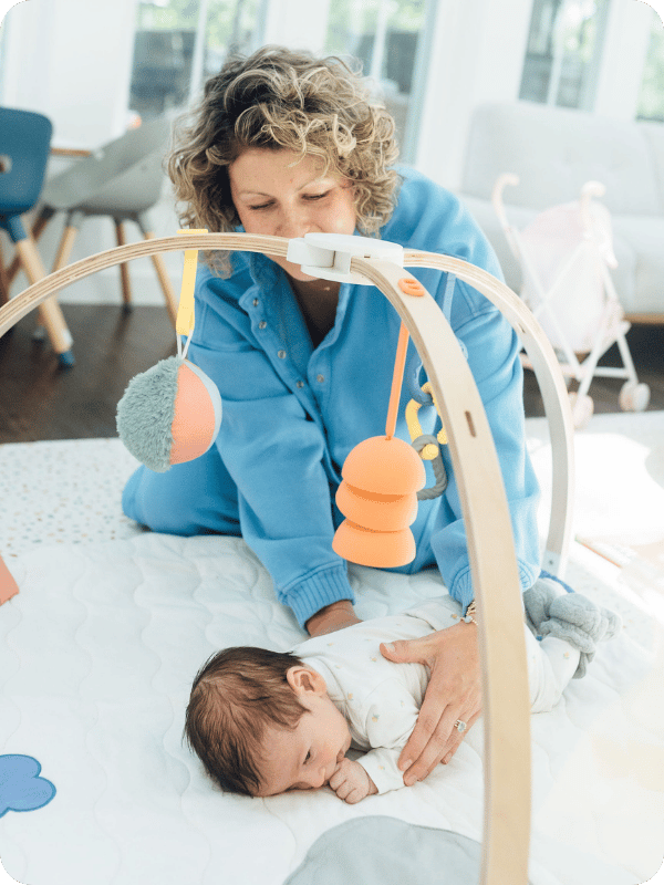 Mom helps baby into tummy time positioning