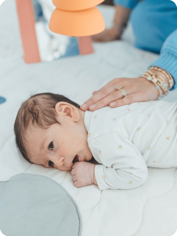 Baby puts her hand to her mouth during tummy time.