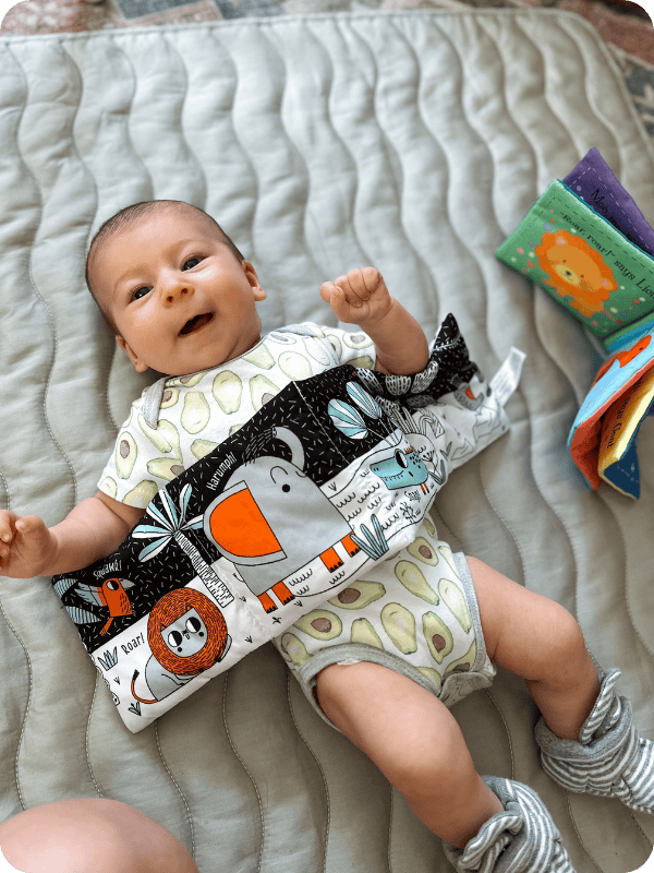 infant lying on their back with a high contrast book