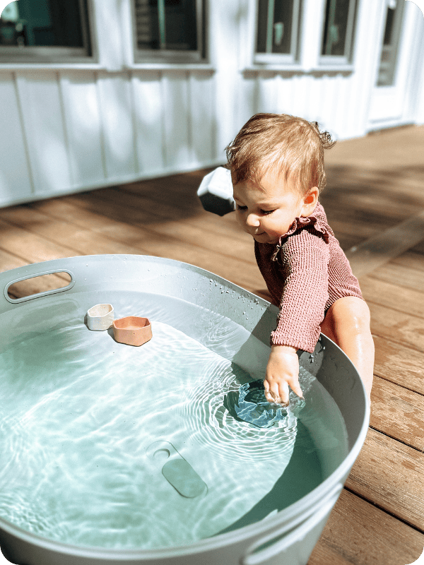 toddler girl playing in Lalo bathtub for sensory play