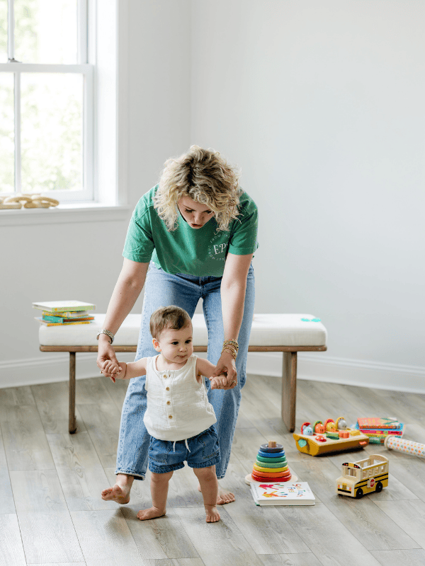 mother helping baby take first steps