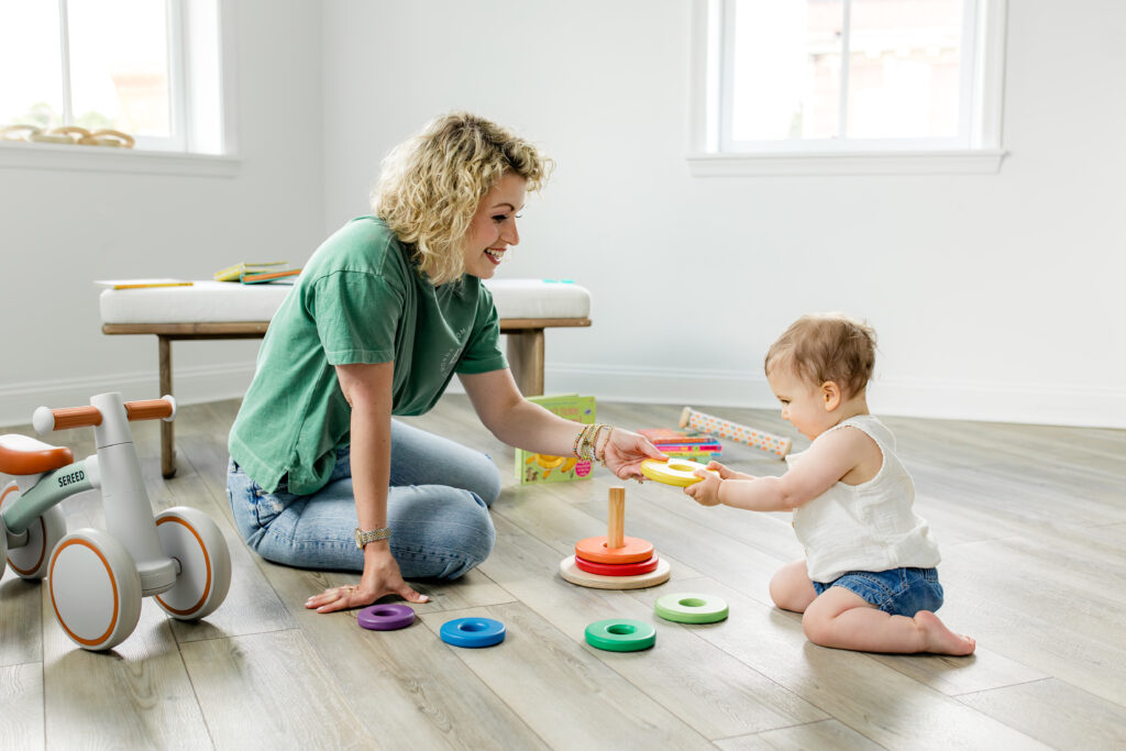 mom plays with ring stacker with baby