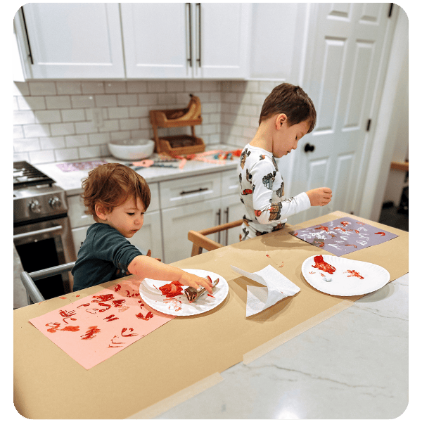 children making valentine's day crafts in kitchen