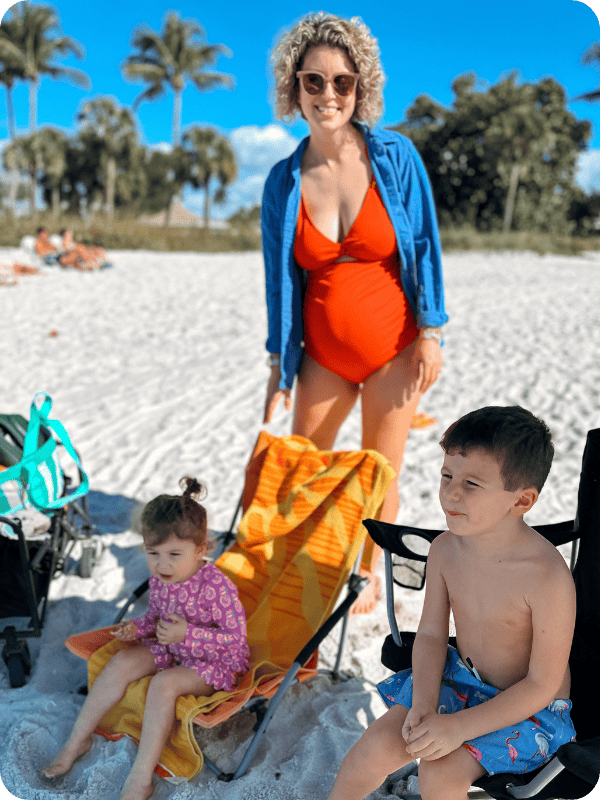 pregnant mom wearing Charmo maternity bathing suit on the beach with 2 toddlers