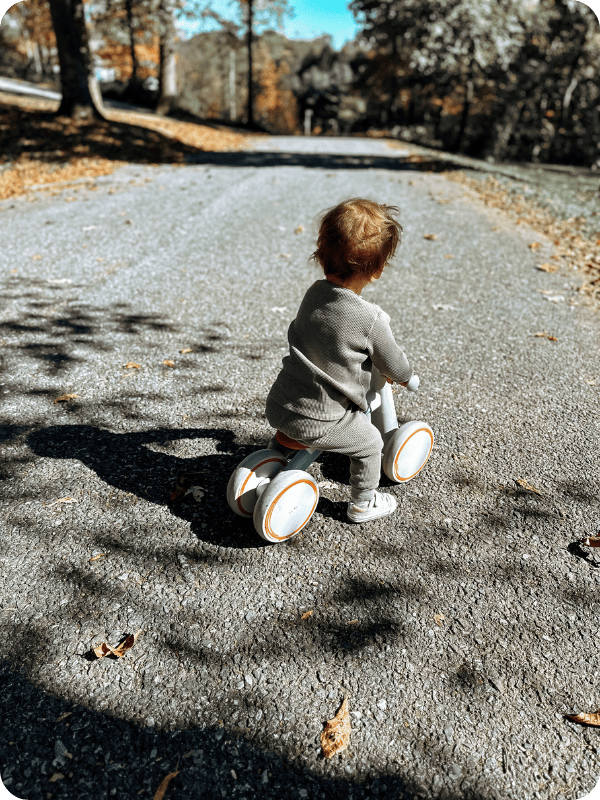 18 month old plays on a balance bike outside