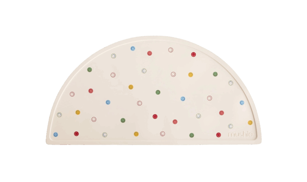mushie placemat with smiley faces