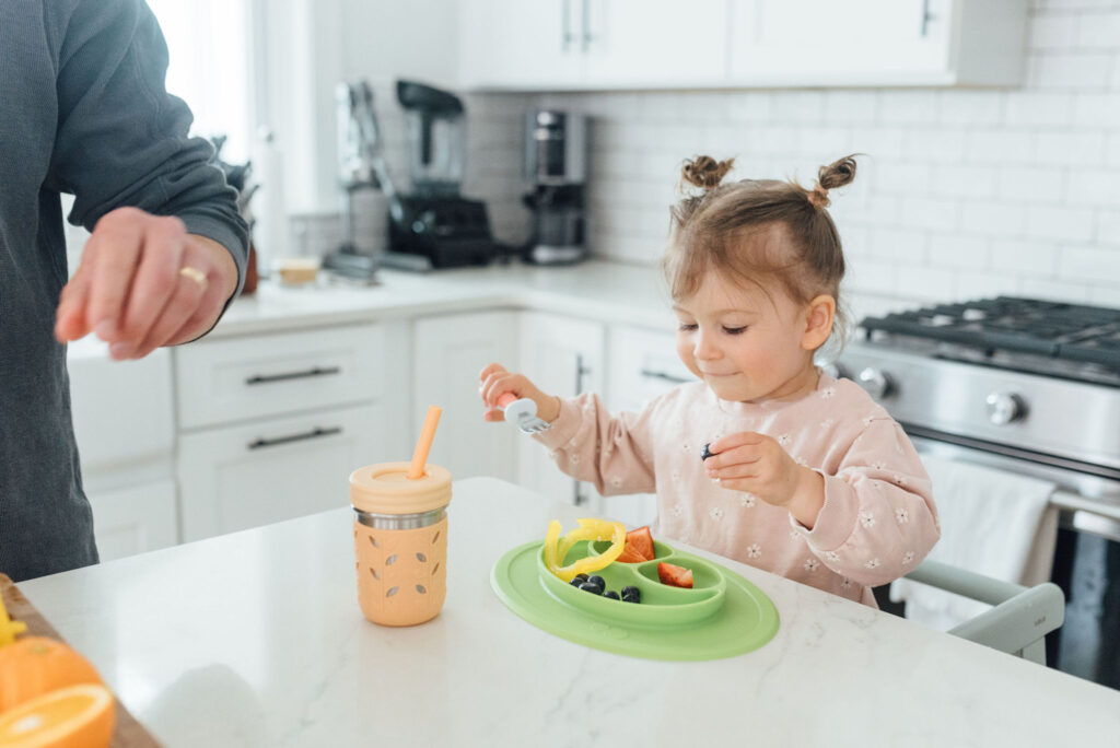 toddler eats and drinks in kitchen