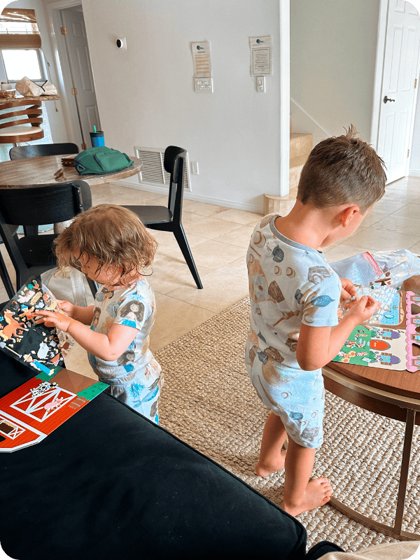 toddlers playing with reusable sticker book
