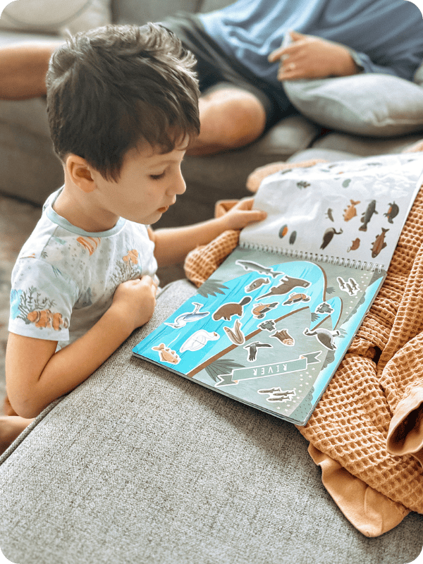 toddler playing with cupkin sticker book