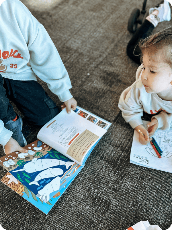 toddlers playing with sticker book at airport
