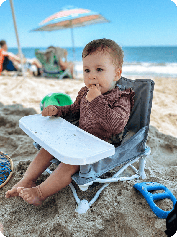 Hiccapop travel booster seat being used on the beach