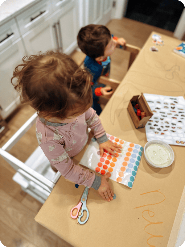 Toddler plays with stickers in a toddler tower