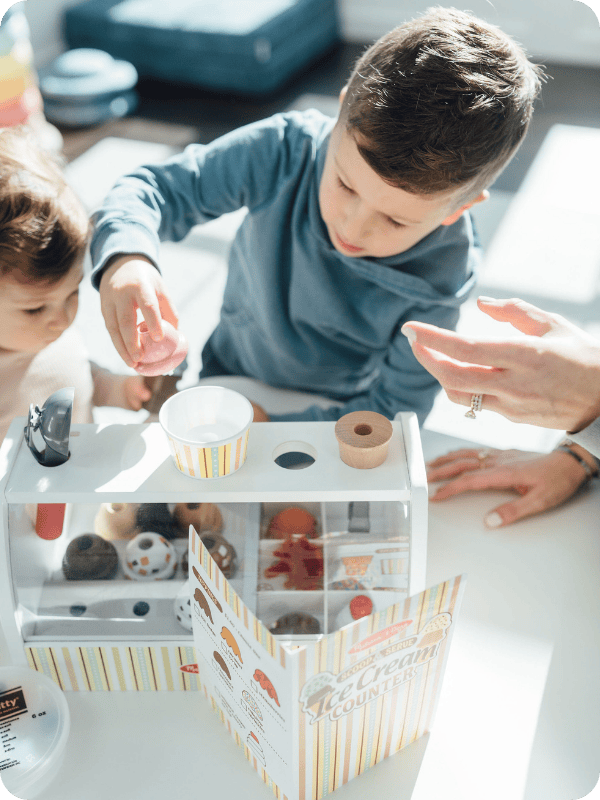 Toddler plays with pretend kitchen food.