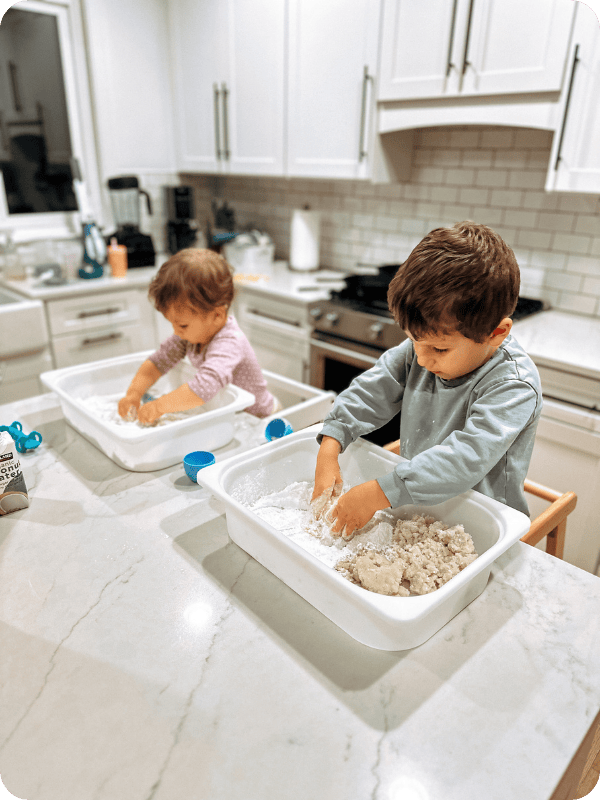 Toddlers playing with sensory bins