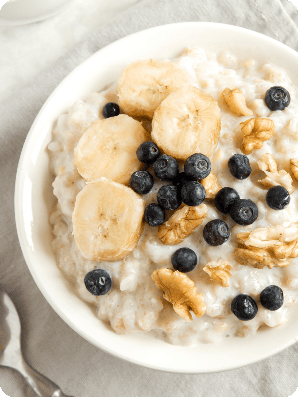 A bowl of oatmeal topped with bananas, blueberries and nuts