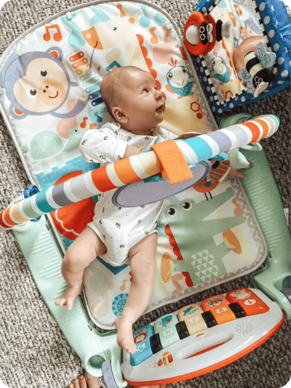 baby on fisher price kick and play gym