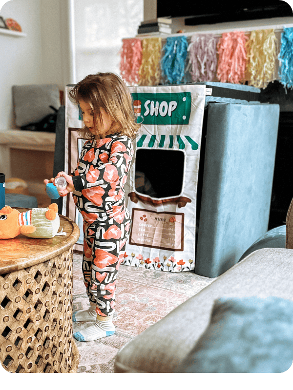 toddler playing with play couch turned into an ice cream shop