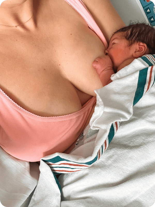 Newborn feeds at the breast