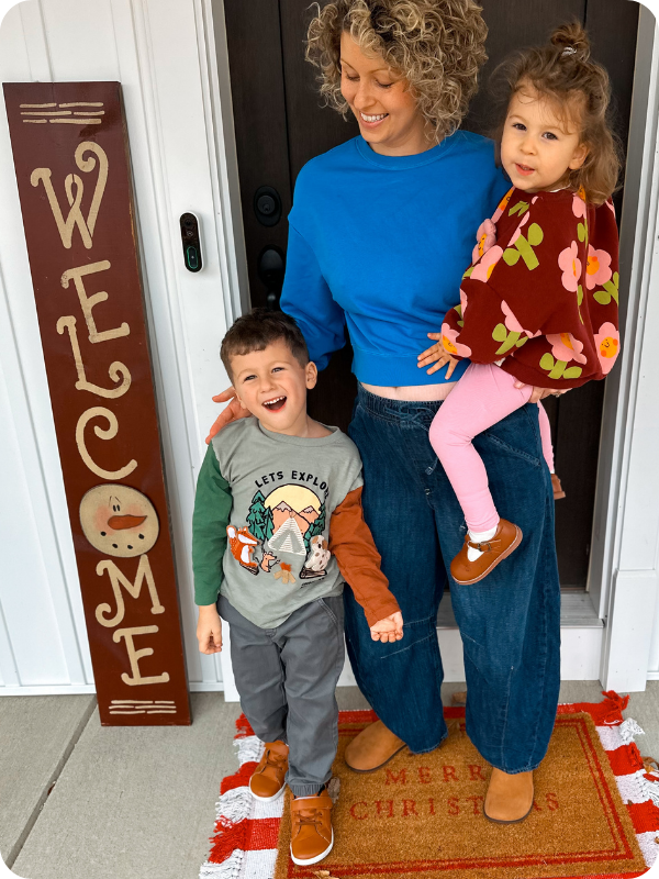 toddlers wearing dress shoes posing for a picture with their mom