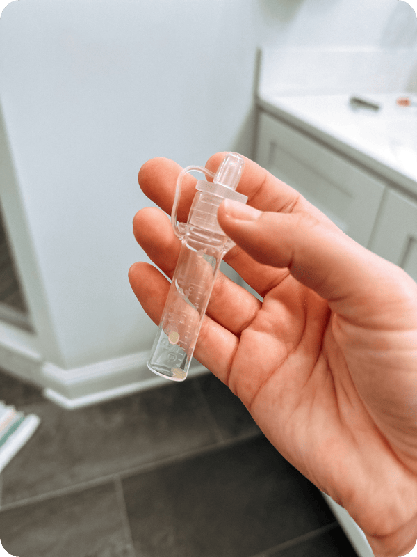 Colostrum collector with 2 drops of colostrum.