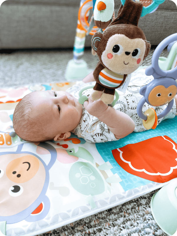 Newborn playing on an activity mat