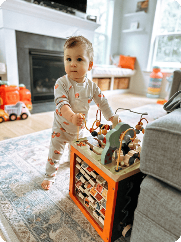 Baby stands at an activity cube